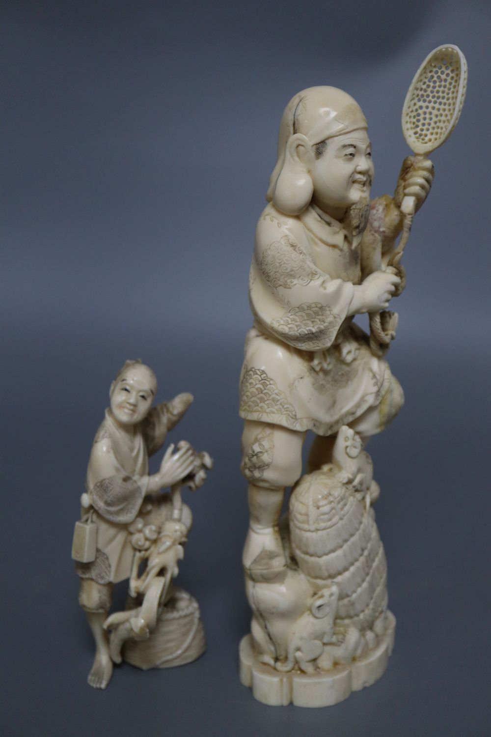 A Japanese ivory okimono of an elder and a dragon, and a marine ivory carving of Daikoku, tallest 25cm
